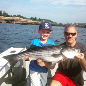 young man holding his catch with the captain